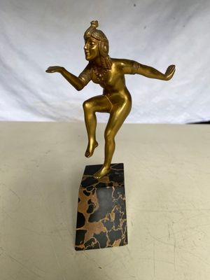 une image représentant une statue en bronze d'une femme posée sur un bloc de marbre