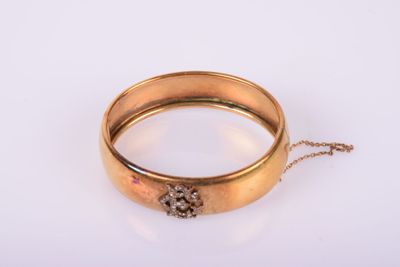 un gros plan d'une bague en or entourée d'une chaîne