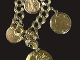 a close up of a chain bracelet with coins on a black background