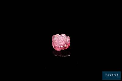 a close up of a pink diamond on a black surface