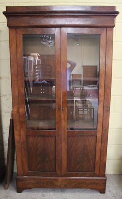 un grand meuble en bois avec des portes en verre dans une pièce