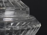 a clear glass container with a lid on a black surface