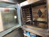 a metal oven with an open door in a kitchen