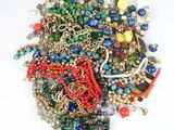 a pile of assorted beads and chains on a white surface