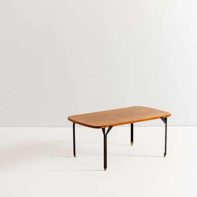 une photo d'une table en bois aux pieds noirs posée sur un sol blanc