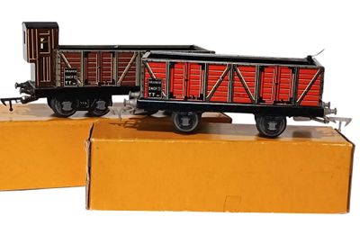 deux petits trains posés sur des cartons, sur une surface blanche