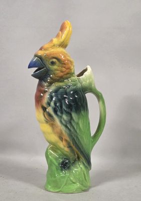 a ceramic bird that is sitting on top of a cup
