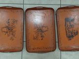 three trays that are sitting on a tile floor