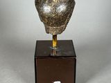 statue of a stone head on a wooden base