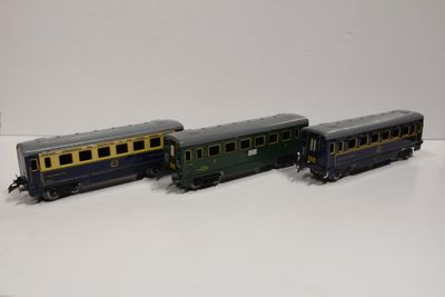 trois petits trains posés les uns à côté des autres sur une surface blanche