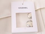 chanel earrings in a white box on a white shirt