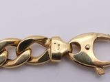 a close up of a gold chain bracelet on a white surface
