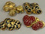 quatre broches dorées, noires et rouges sont posées sur une surface blanche
