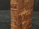 an old book with a note sticking out of it sitting on a table