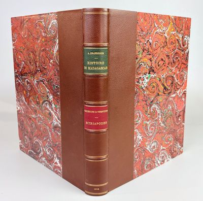 un livre marron à la couverture rouge et un livre vert au milieu