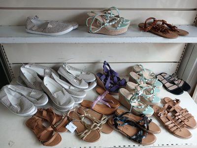 many pairs of shoes on a shelf in a room