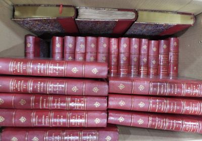 de nombreux livres rouges empilés dans une boîte posée par terre
