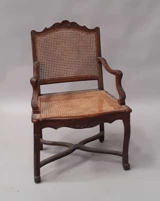 une vieille chaise en bois avec un dossier et une assise en rotin