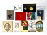 beaucoup de livres et de pièces de monnaie posés sur une surface blanche