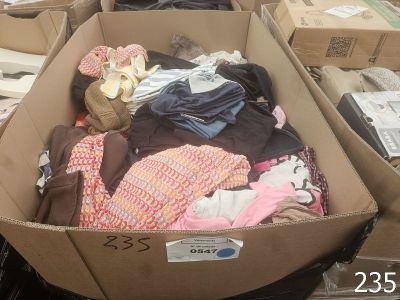 une boîte en carton remplie de vêtements et d'une peluche