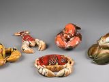 several small ceramic figurines of animals and birds on a gray surface