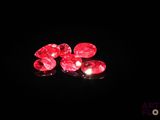 a close up of a pair of red diamonds on a black surface