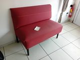 un canapé rouge qui se trouve dans une pièce au sol carrelé