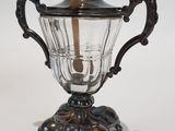 a silver and glass teapot with a wooden handle on a stand
