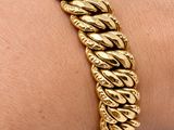 an image of a gold bracelet on a woman ' s arm