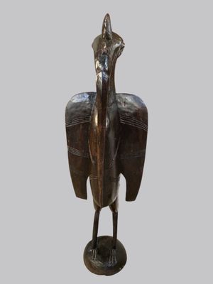 statue of a bird on a pedestal on a gray background