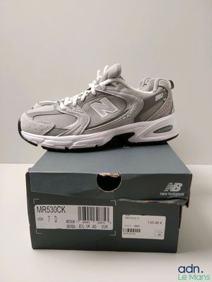 une paire de chaussures New Balance posée sur une boîte