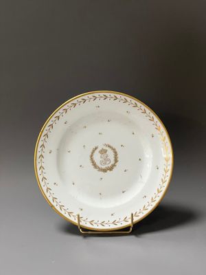 a white and gold plate with a gold decoration on it