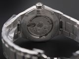 close up of a watch on a black surface with a chain around it