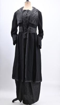 an image of a mannequin dressed in a black coat and skirt