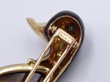 an image of a gold and tortoise broochle with a black and gold pin
