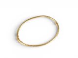 a close up of a gold bracelet on a white surface