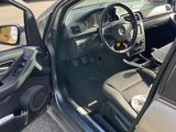 the interior of a car with the door open and the driver ' s seat down