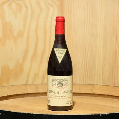 a bottle of wine sitting on top of a barrel