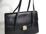 black leather handbag with a gold lock on the front