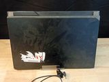 a laptop computer sitting on a wooden table with a charger