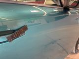 a close up of a blue car with a sticker on it