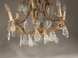 an antique brass chandelier with clear glass drops hanging from the ceiling
