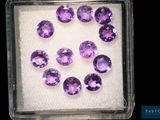 un gros plan sur un tas de pierres précieuses violettes dans un récipient en plastique