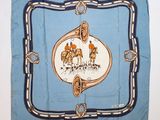une photo d'une écharpe bleue sur laquelle figurent des chevaux et des cavaliers