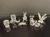quatre figurines en verre représentant des oiseaux et des fleurs, posées sur une table