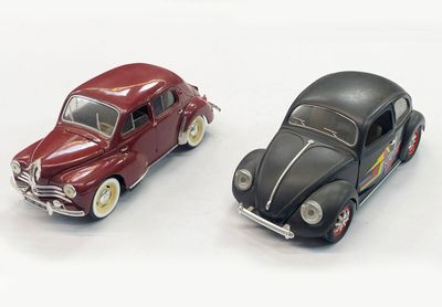 two toy cars sitting next to each other on a white surface