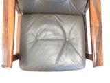 a black leather chair with a wooden frame and foot rest