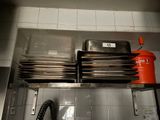 a stack of plates and pans on a shelf in a kitchen