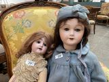 a doll and a doll sitting on a chair