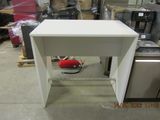 a small white table with a red bag on it